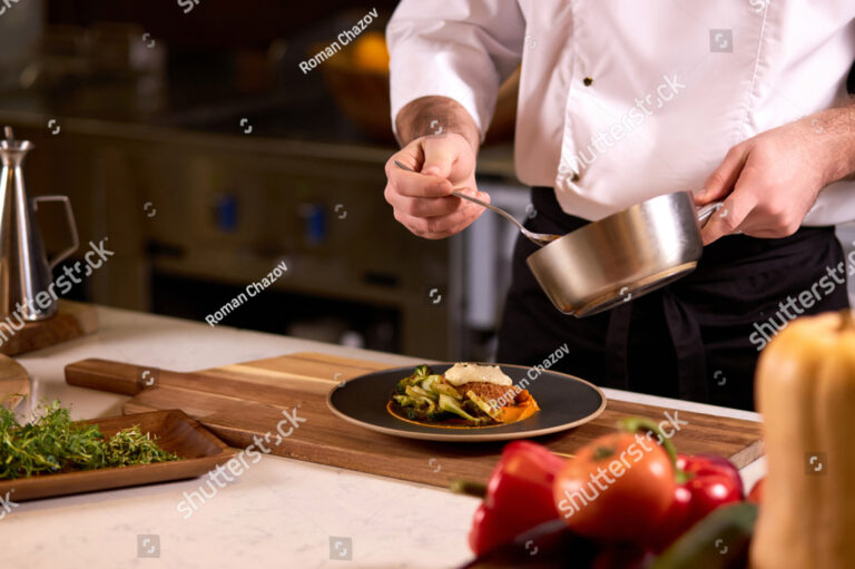 stock-photo-chef-dressing-salad-with-sauce-pouring-sauce-into-plate-finishing-cooking-of-meal-in-restaurant-1923169079
